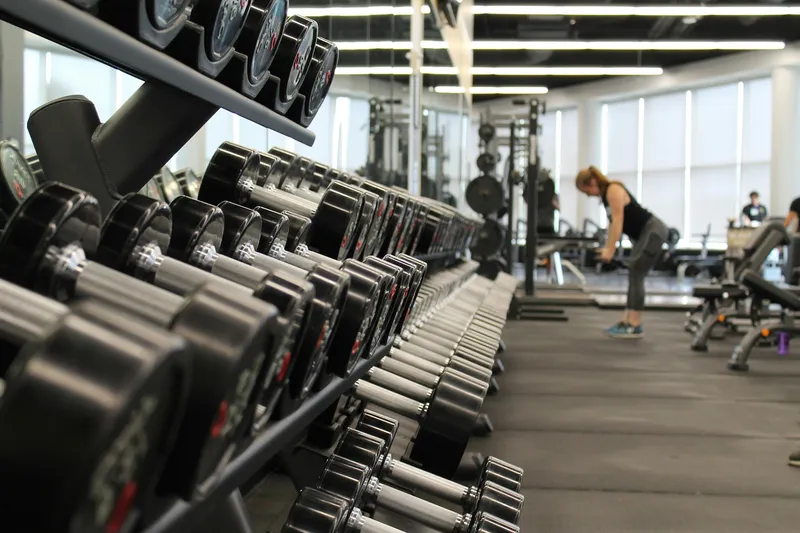 Silhouetted person working out with rings against dark background